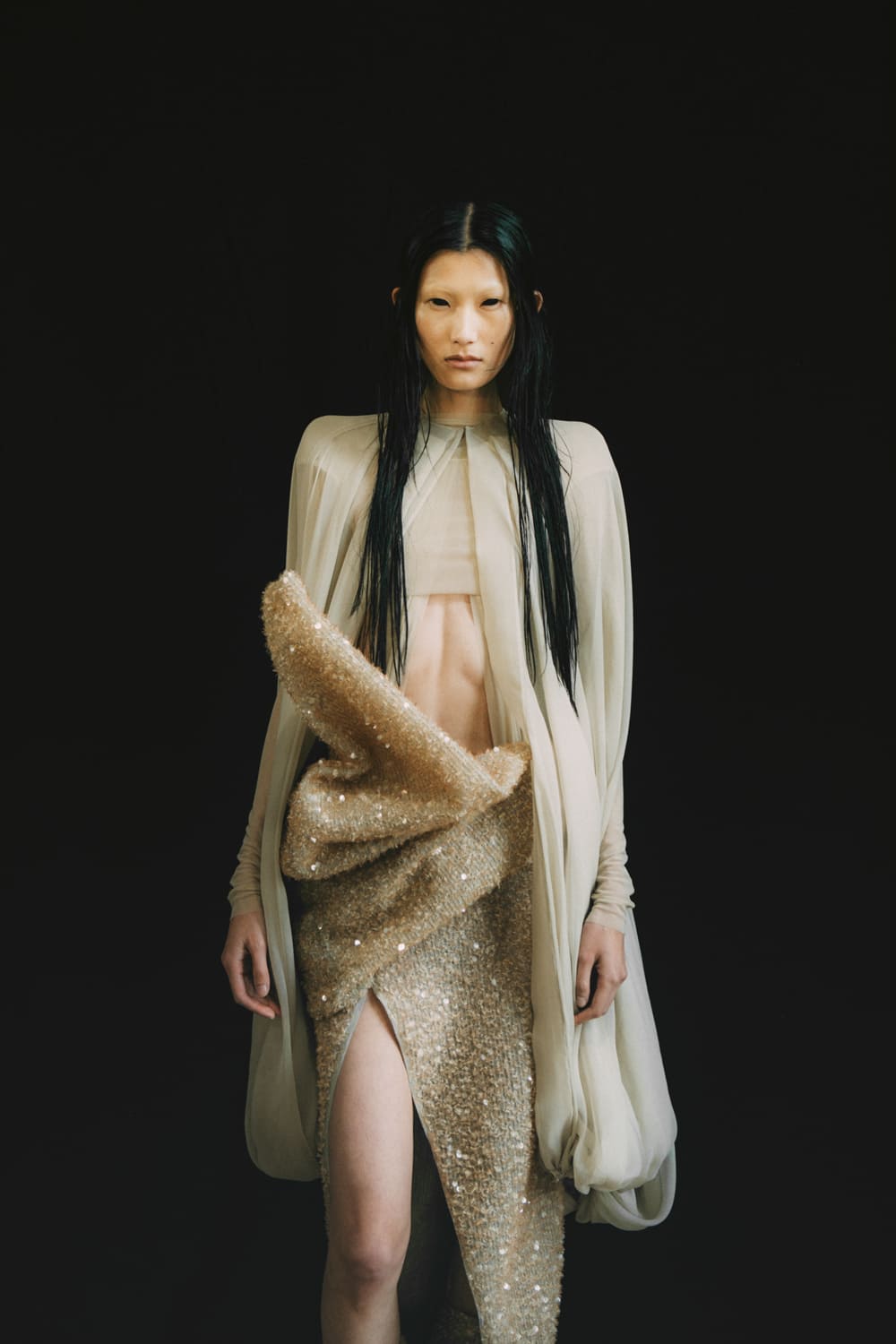 Rick Owens runway look featuring avant garde layered outfit with sculptural silhouette and dark tonal styling