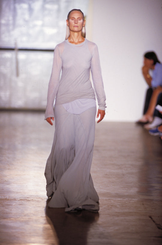 Rick Owens runway look featuring avant garde layered outfit with sculptural silhouette and dark tonal styling