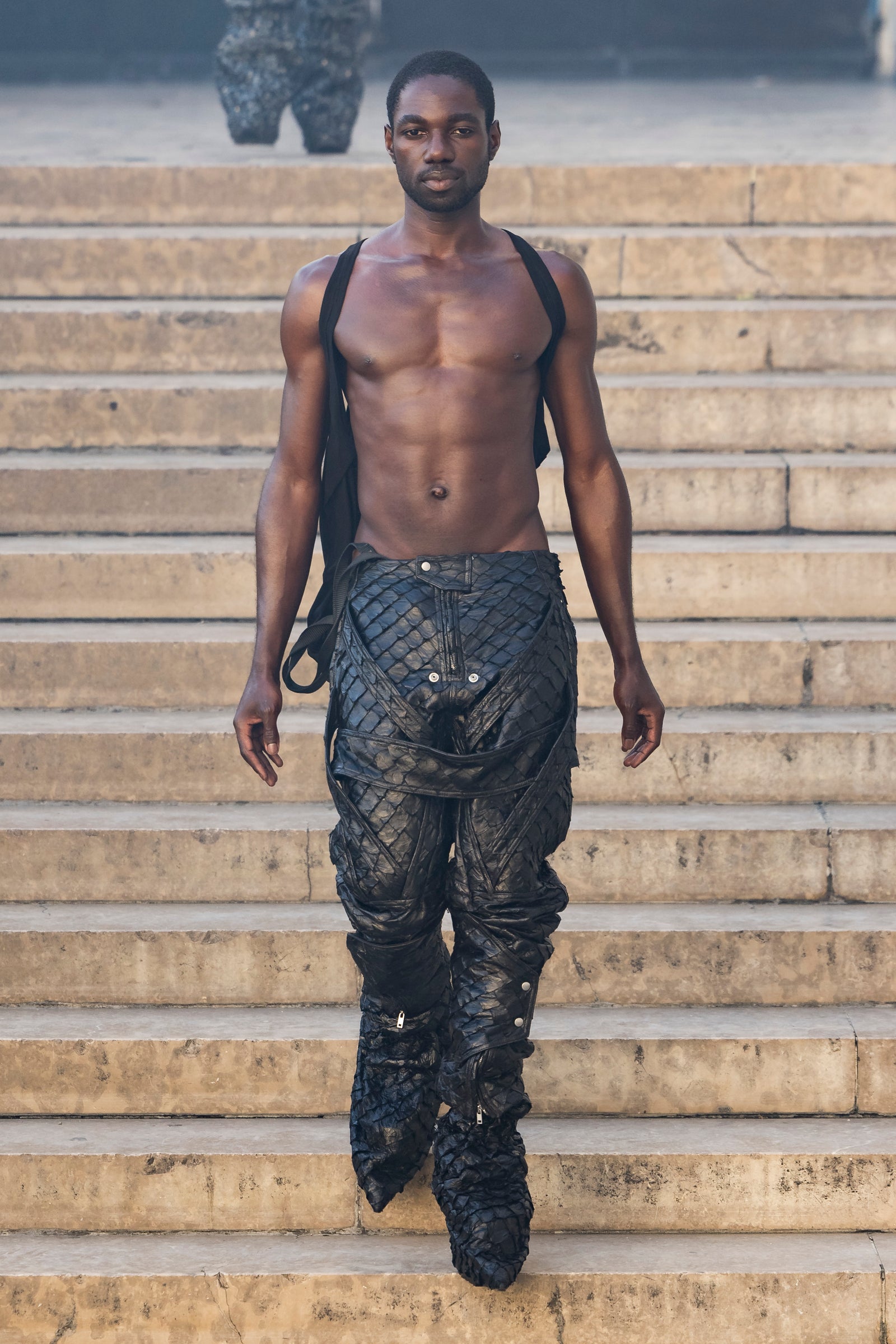 Rick Owens runway look featuring avant garde layered outfit with sculptural silhouette and dark tonal styling