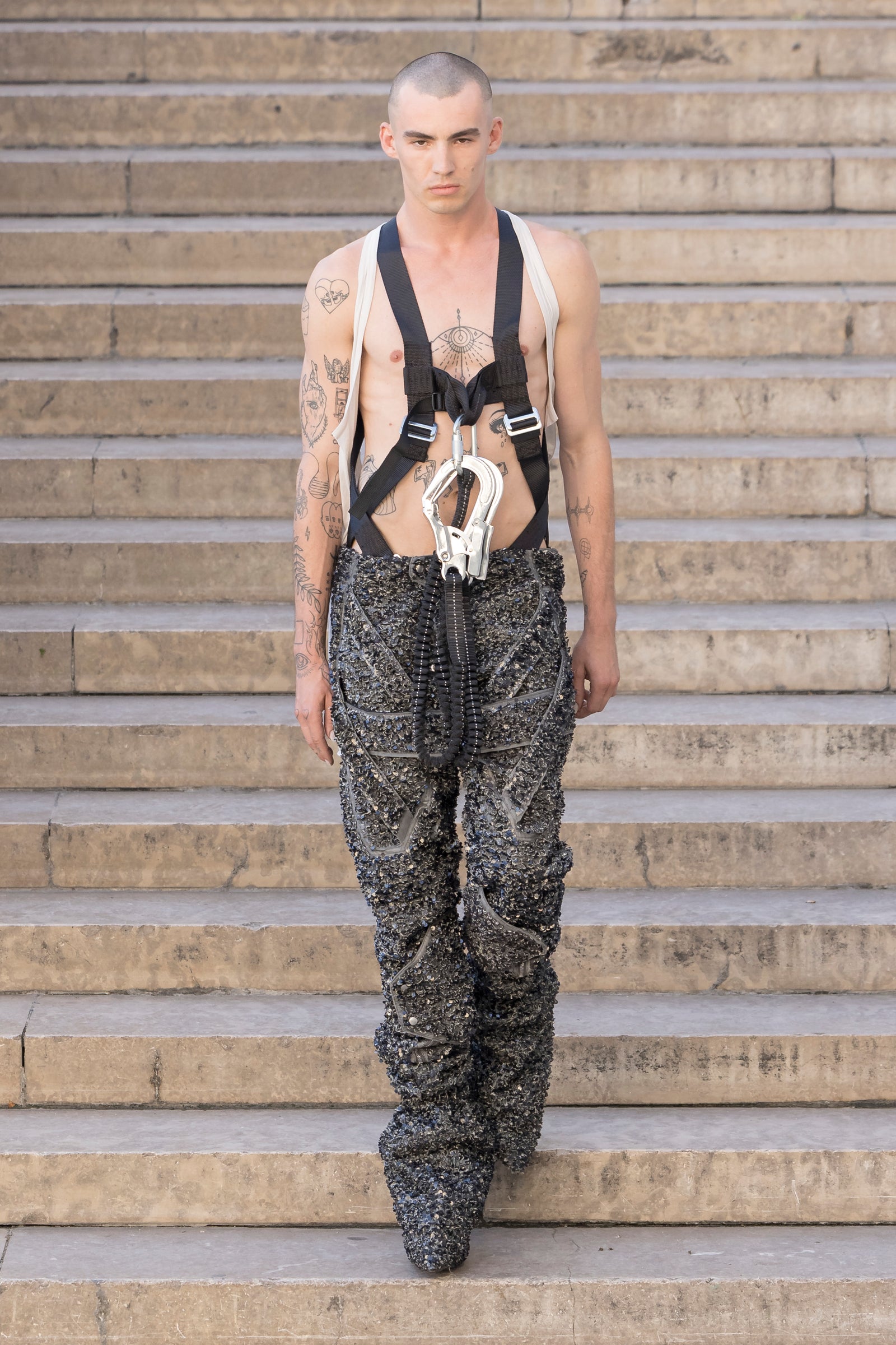 Rick Owens runway look featuring avant garde layered outfit with sculptural silhouette and dark tonal styling