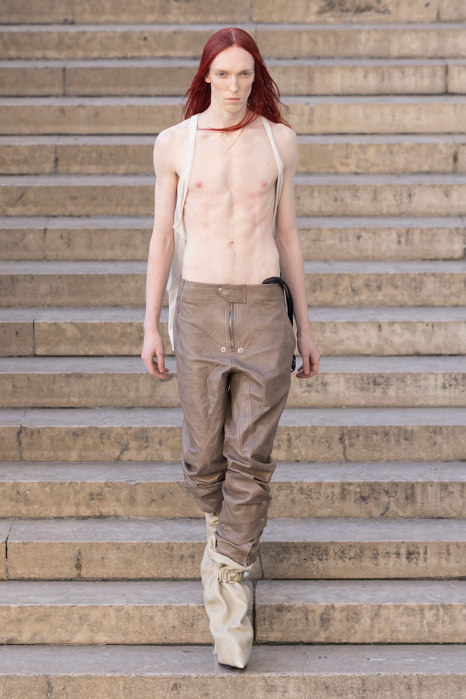 Rick Owens runway look featuring avant garde layered outfit with sculptural silhouette and dark tonal styling