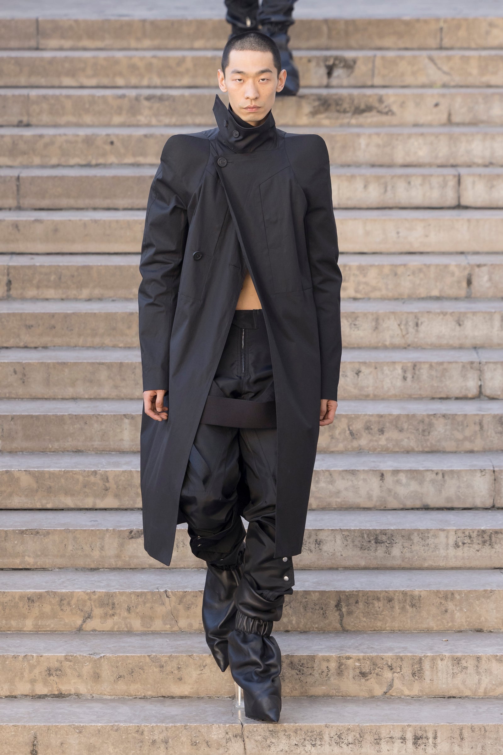 Rick Owens runway look featuring avant garde layered outfit with sculptural silhouette and dark tonal styling