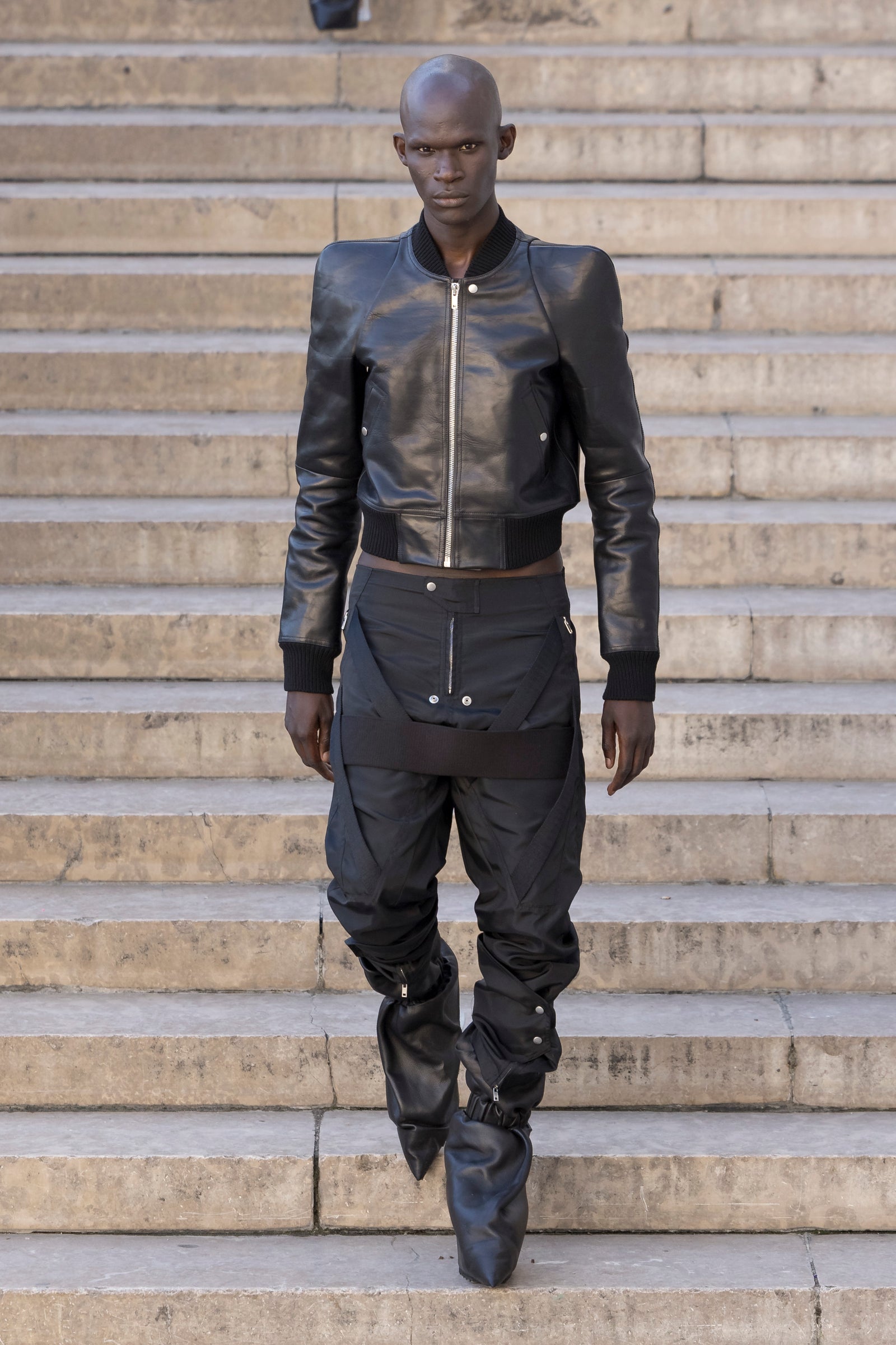 Rick Owens runway look featuring avant garde layered outfit with sculptural silhouette and dark tonal styling