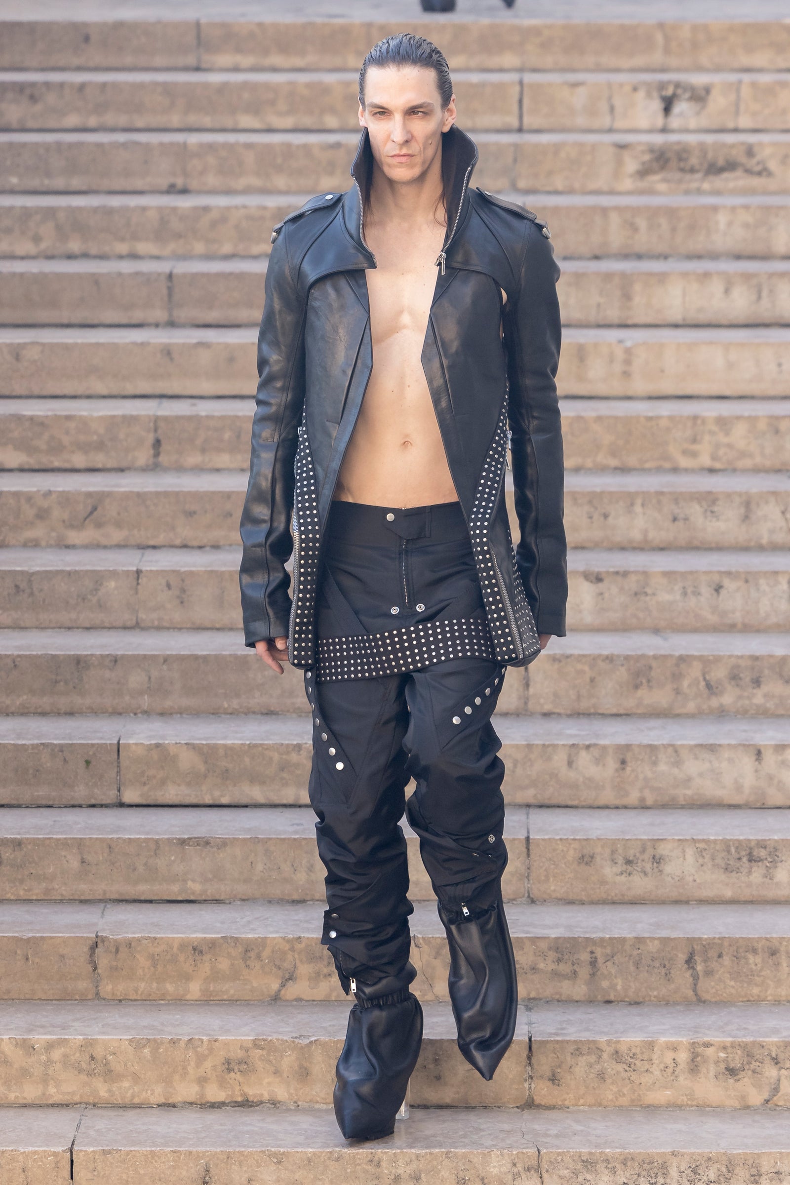 Rick Owens runway look featuring avant garde layered outfit with sculptural silhouette and dark tonal styling