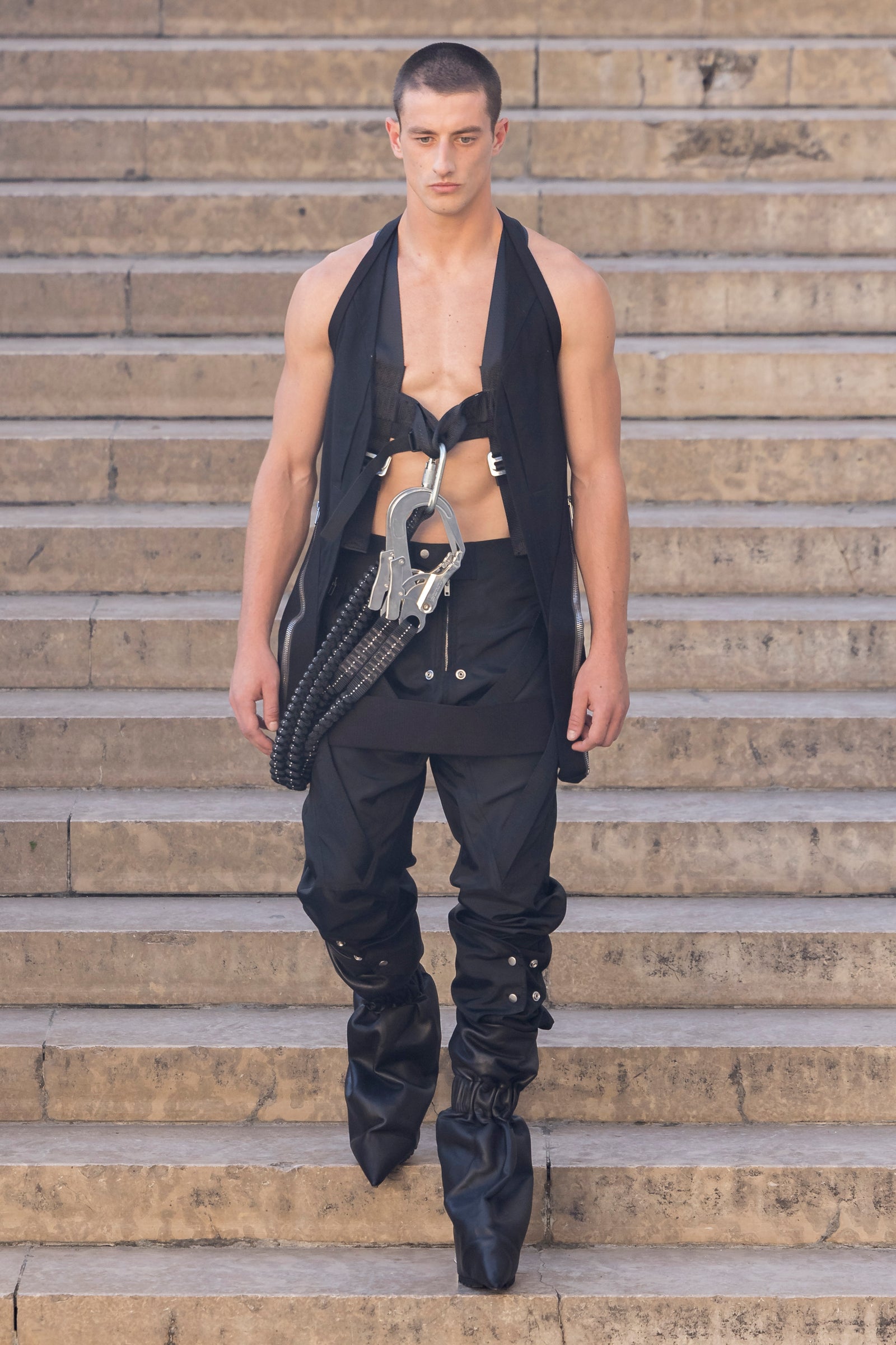 Rick Owens runway look featuring avant garde layered outfit with sculptural silhouette and dark tonal styling