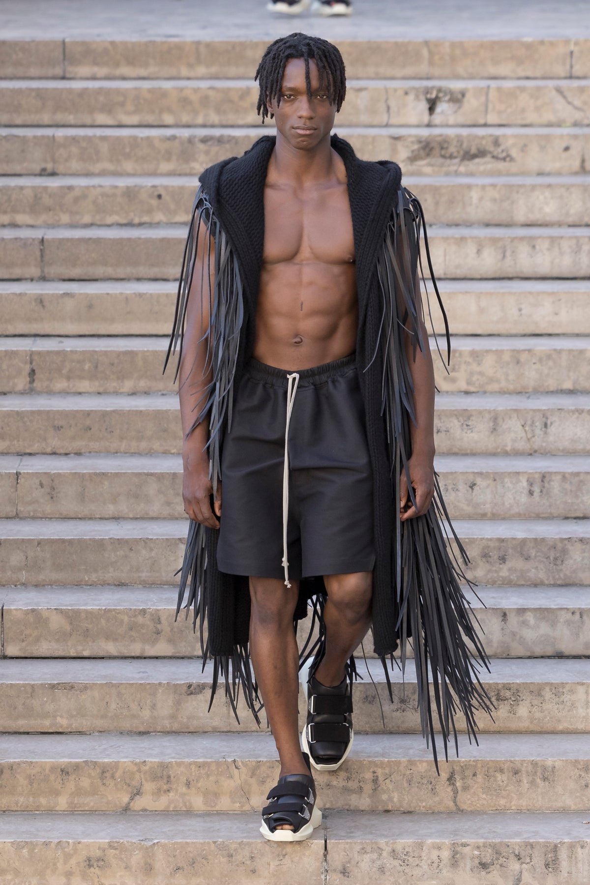 Rick Owens runway look featuring avant garde layered outfit with sculptural silhouette and dark tonal styling