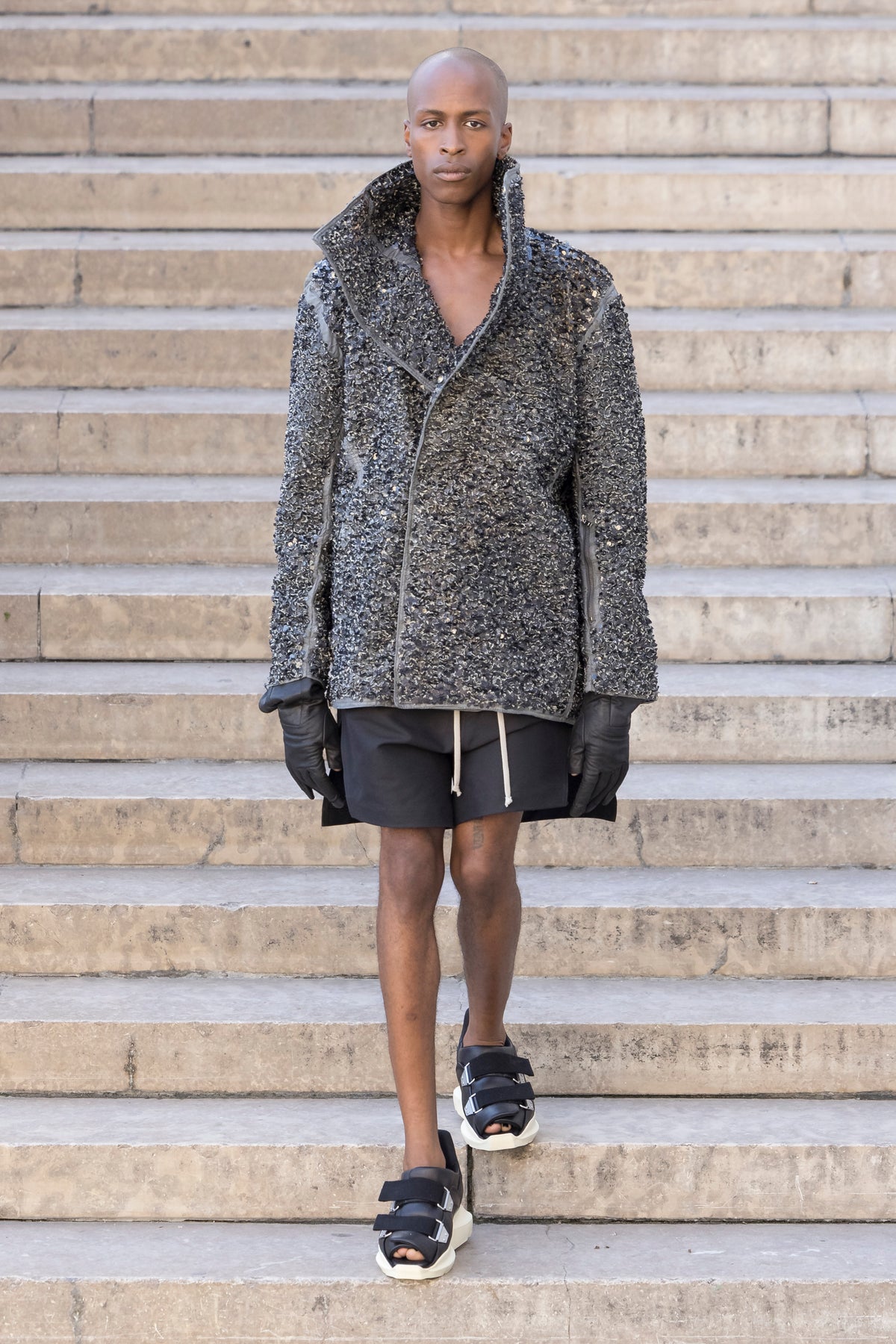 Rick Owens runway look featuring avant garde layered outfit with sculptural silhouette and dark tonal styling