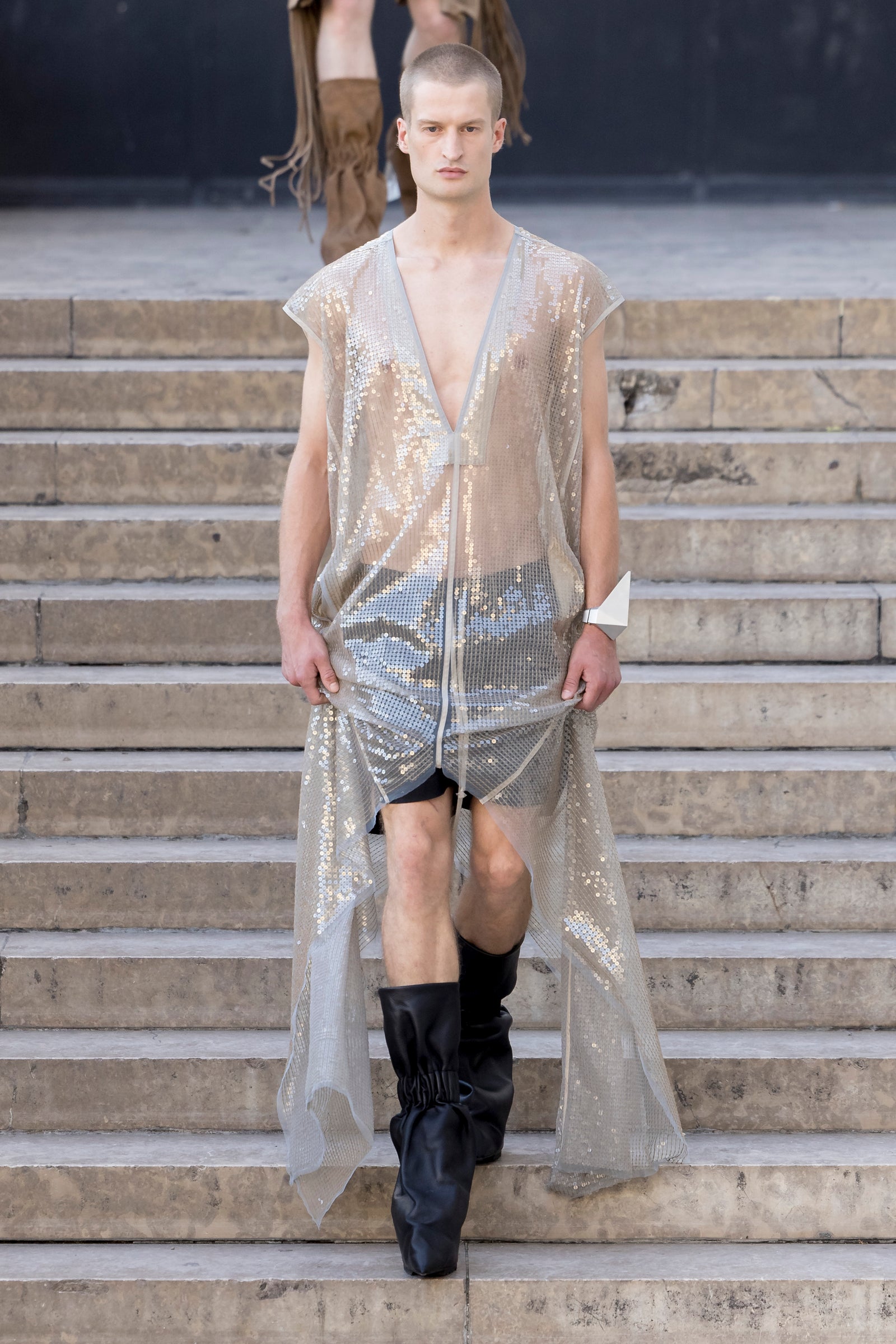 Rick Owens runway look featuring avant garde layered outfit with sculptural silhouette and dark tonal styling