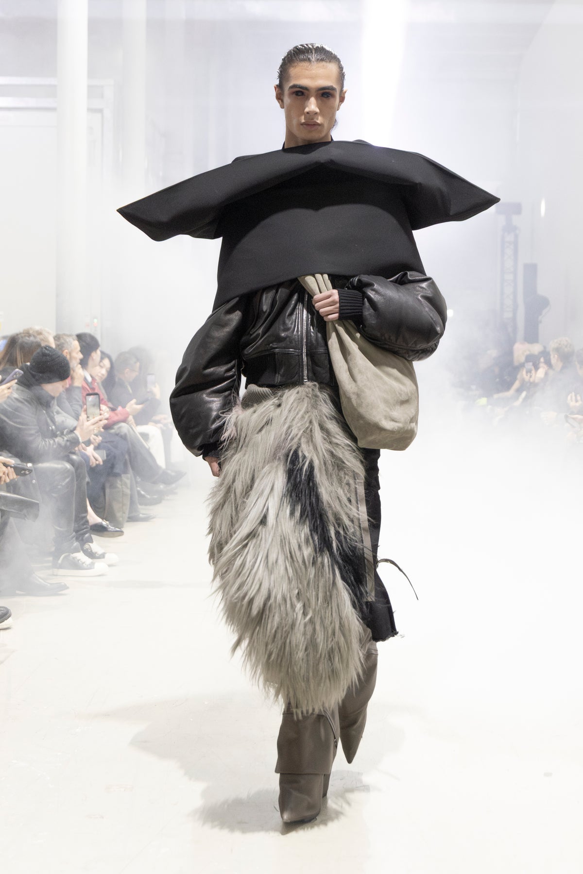 Rick Owens runway look featuring avant garde layered outfit with sculptural silhouette and dark tonal styling