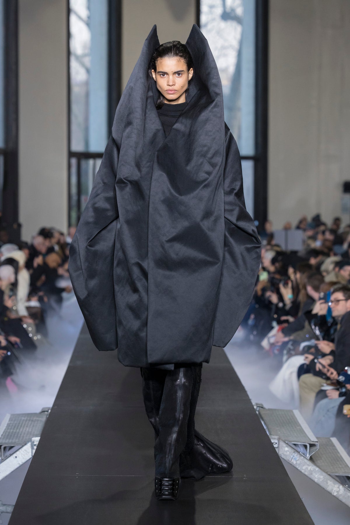 Rick Owens runway look featuring avant garde layered outfit with sculptural silhouette and dark tonal styling