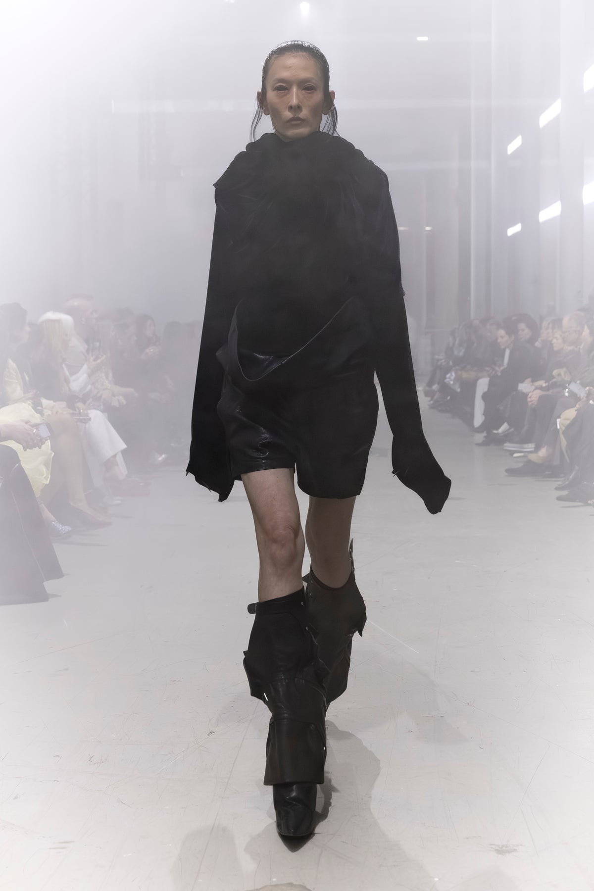 Rick Owens runway look featuring avant garde layered outfit with sculptural silhouette and dark tonal styling