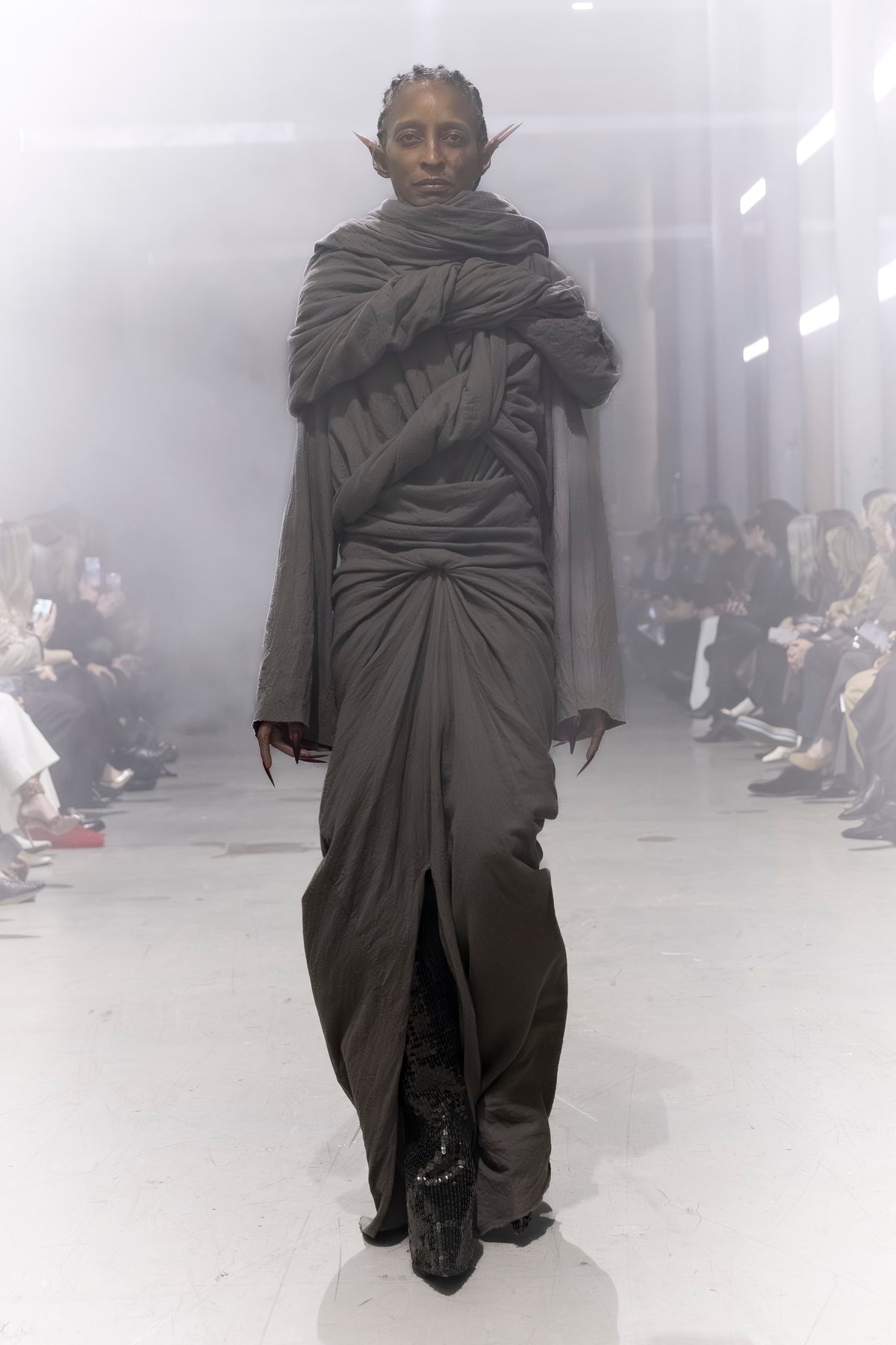 Rick Owens runway look featuring avant garde layered outfit with sculptural silhouette and dark tonal styling