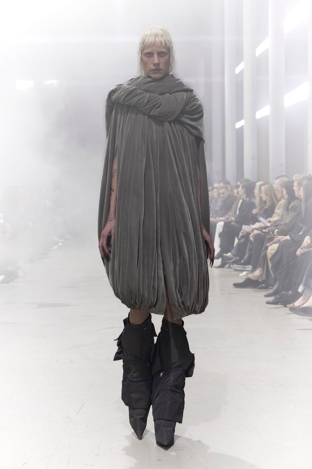 Rick Owens runway look featuring avant garde layered outfit with sculptural silhouette and dark tonal styling
