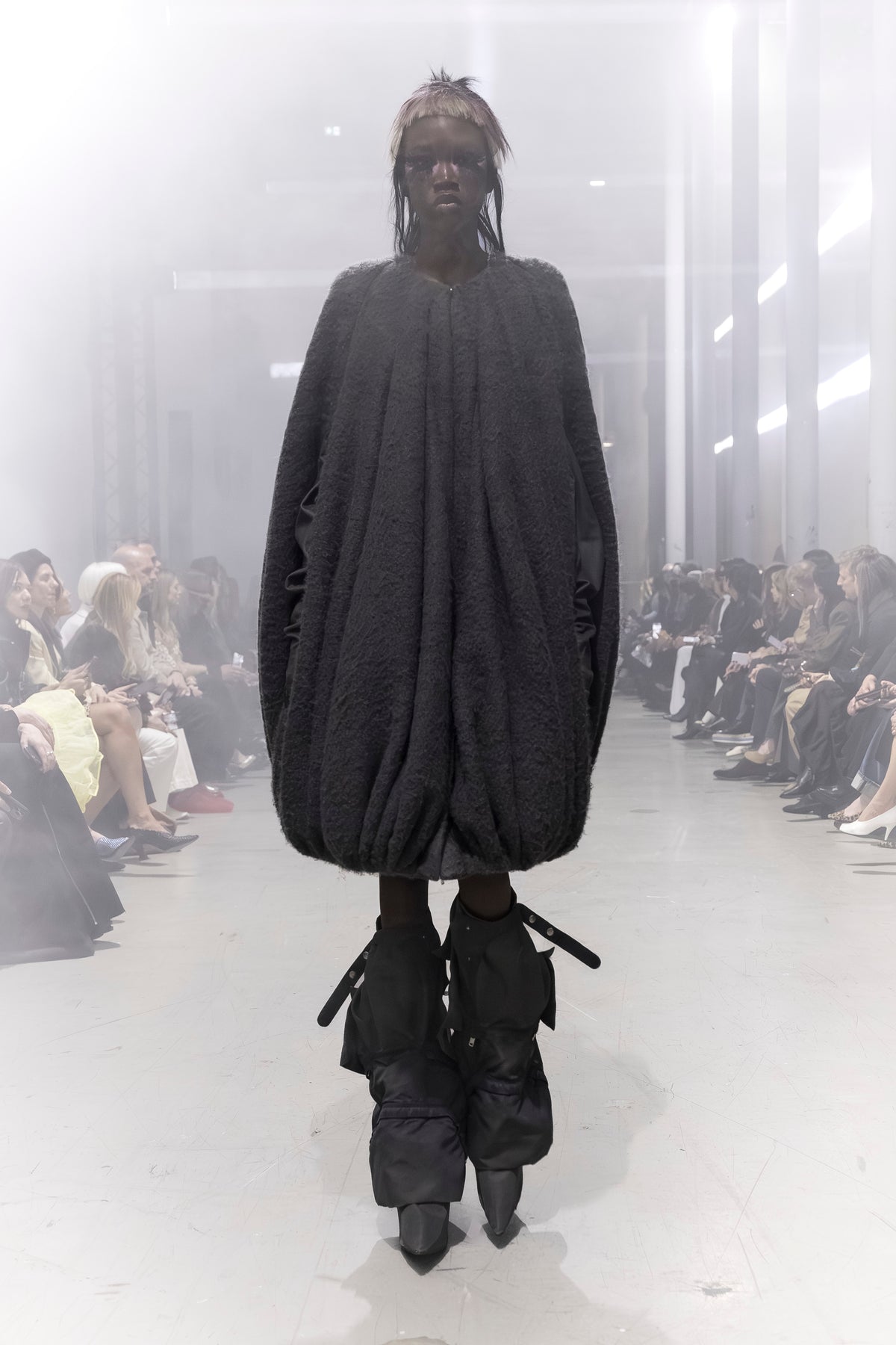 Rick Owens runway look featuring avant garde layered outfit with sculptural silhouette and dark tonal styling