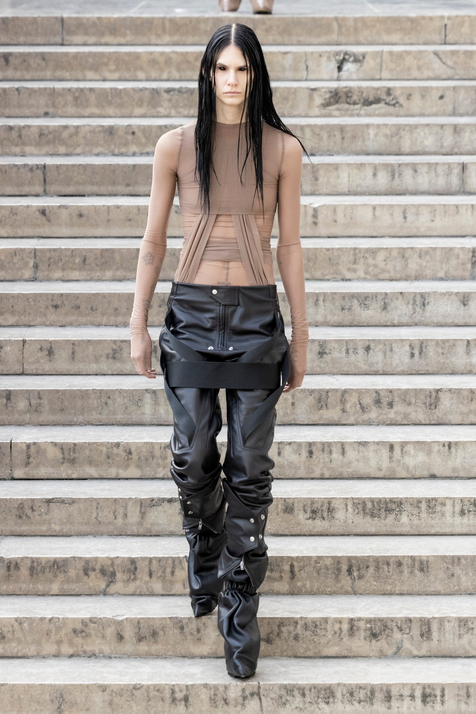 Rick Owens runway look featuring avant garde layered outfit with sculptural silhouette and dark tonal styling