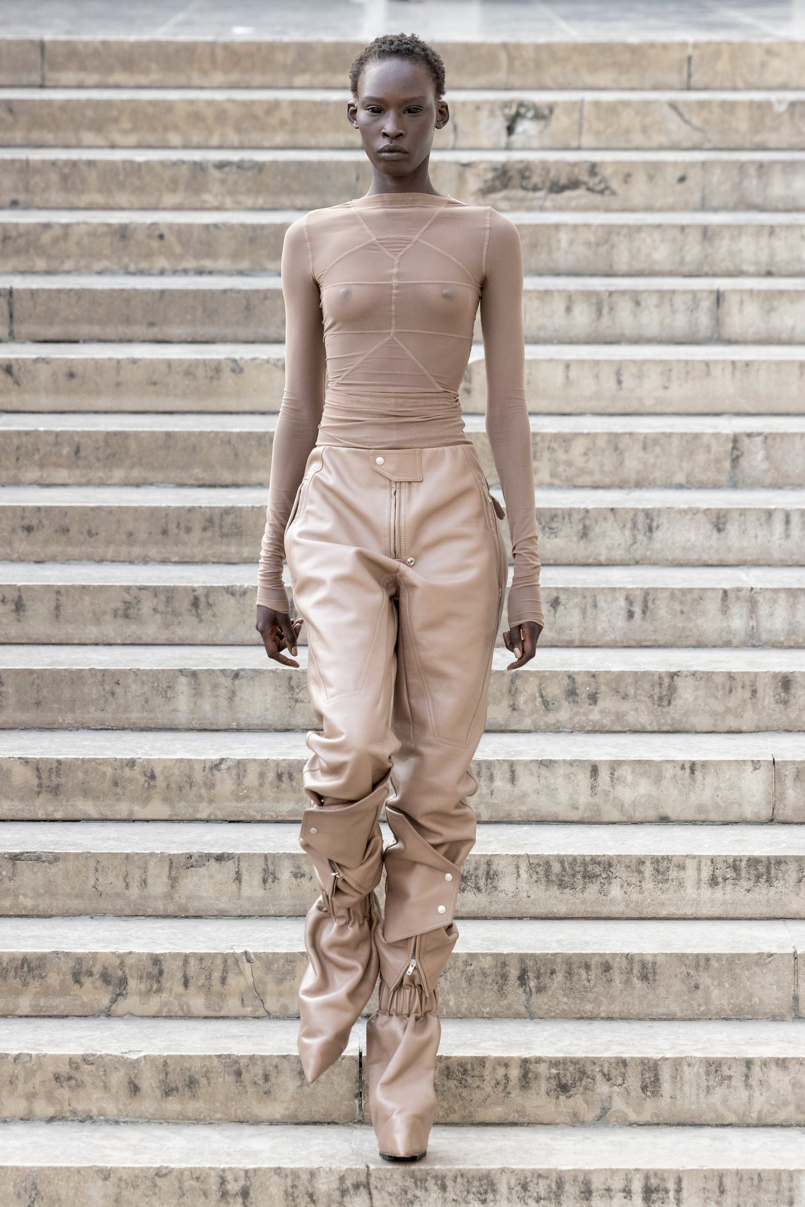 Rick Owens runway look featuring avant garde layered outfit with sculptural silhouette and dark tonal styling