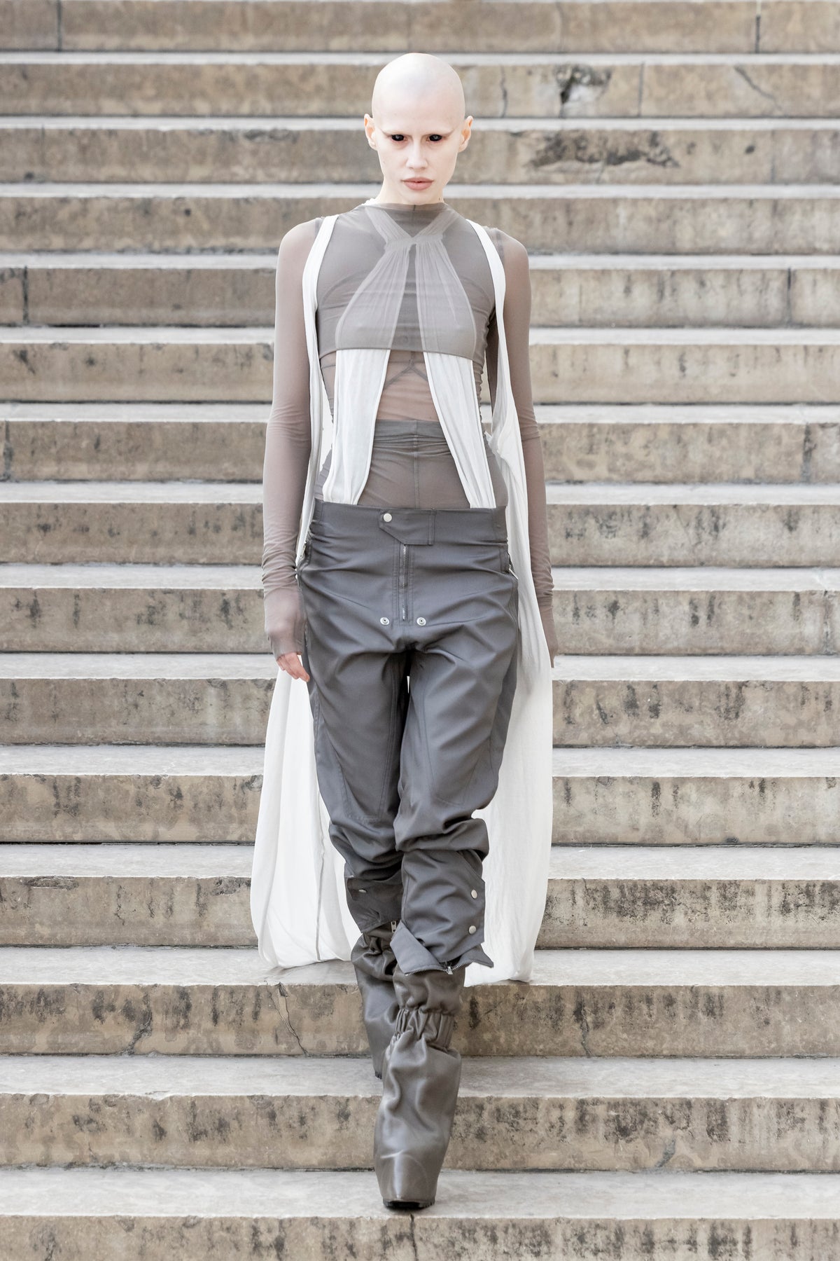 Rick Owens runway look featuring avant garde layered outfit with sculptural silhouette and dark tonal styling