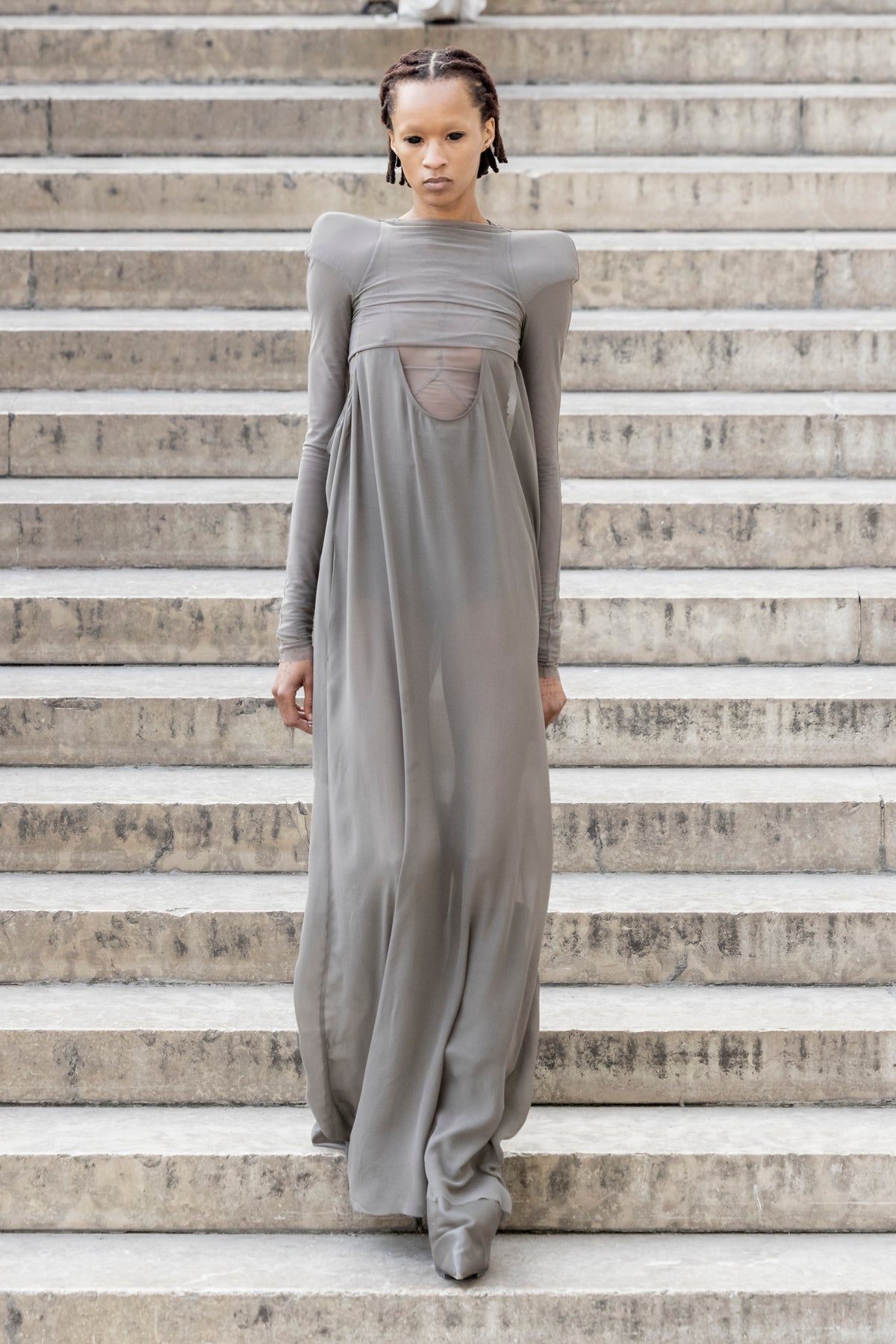 Rick Owens runway look featuring avant garde layered outfit with sculptural silhouette and dark tonal styling