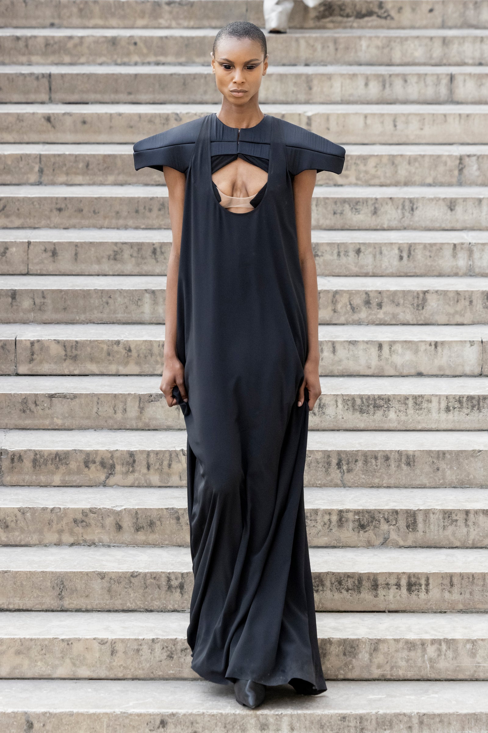 Rick Owens runway look featuring avant garde layered outfit with sculptural silhouette and dark tonal styling