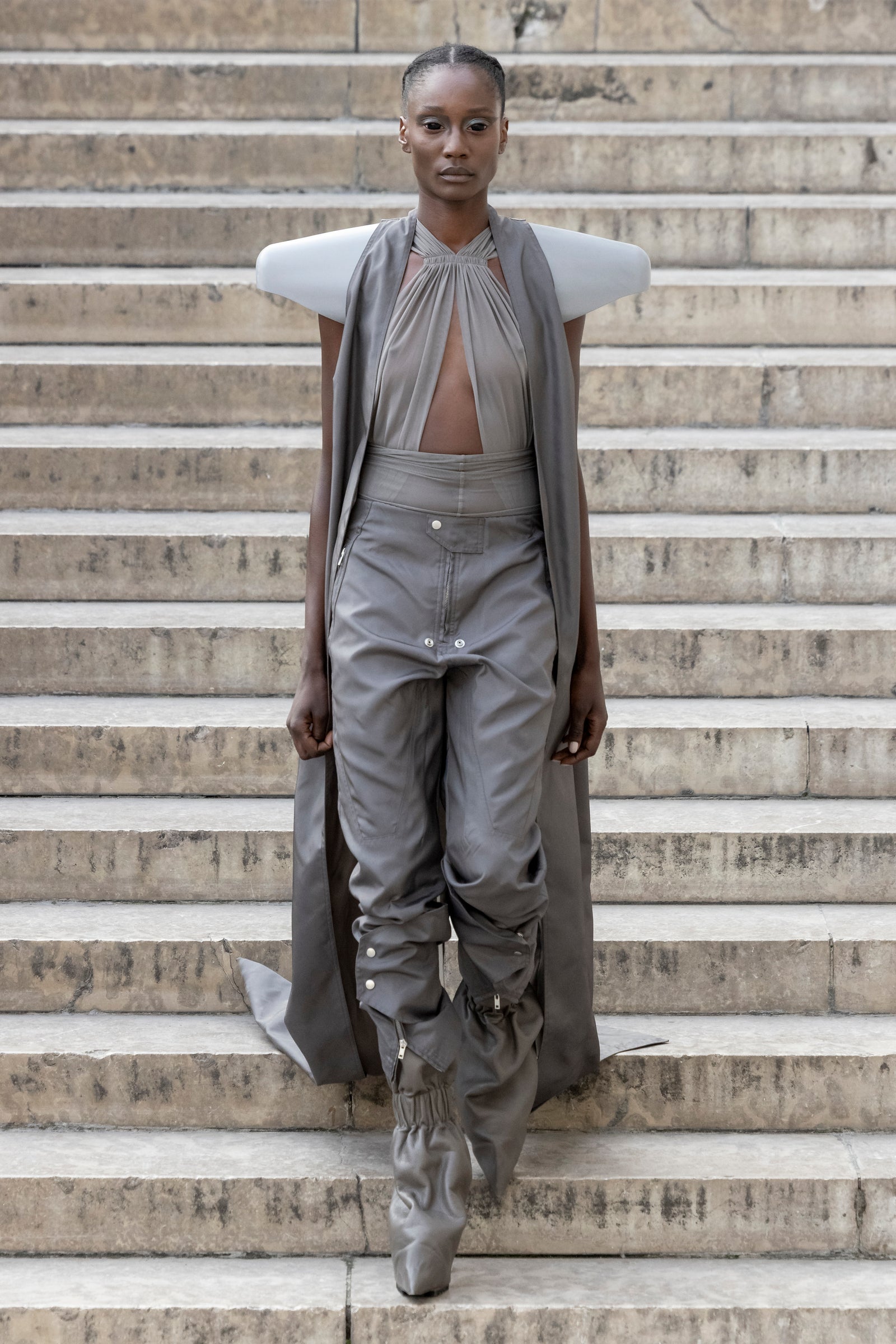 Rick Owens runway look featuring avant garde layered outfit with sculptural silhouette and dark tonal styling