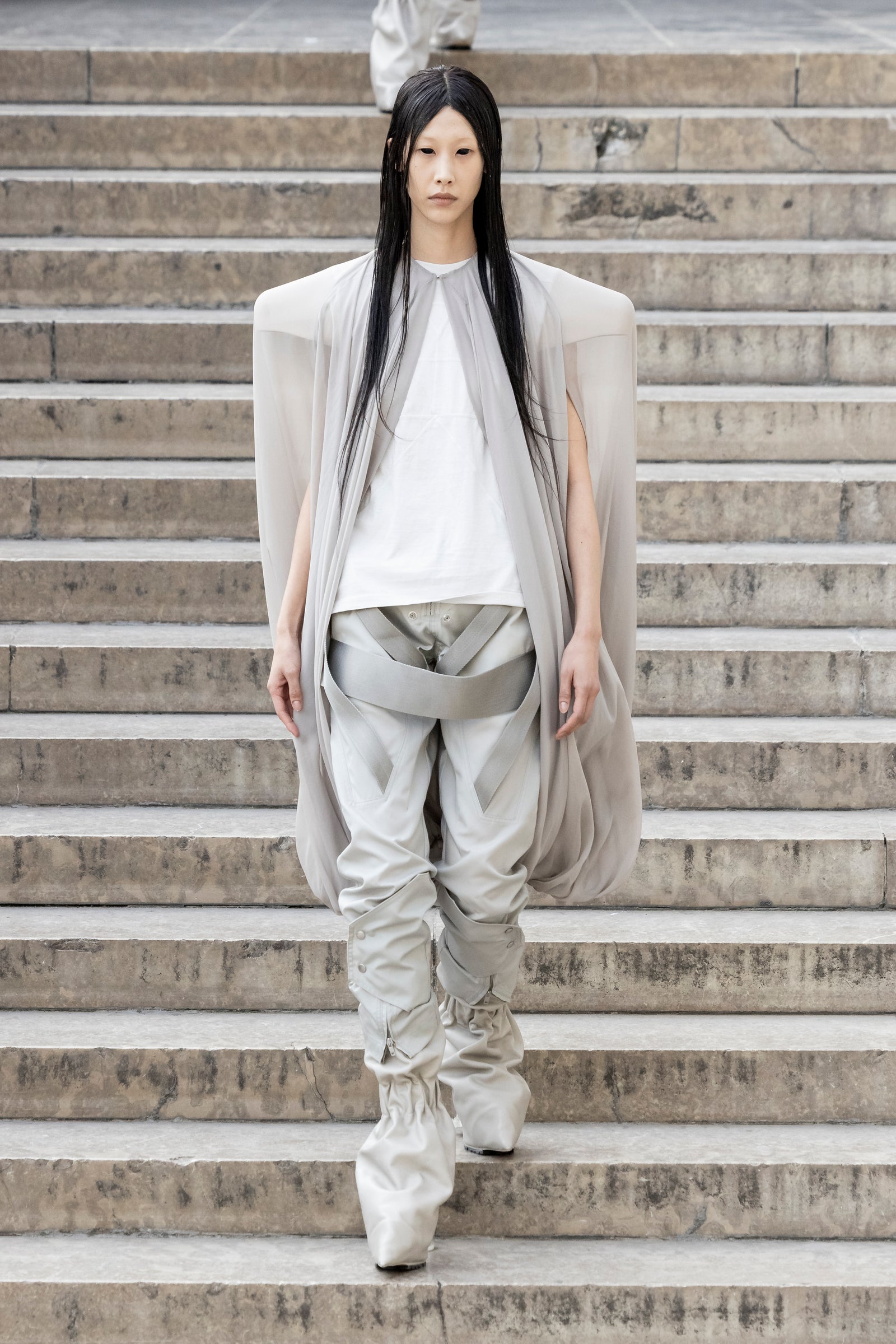 Rick Owens runway look featuring avant garde layered outfit with sculptural silhouette and dark tonal styling