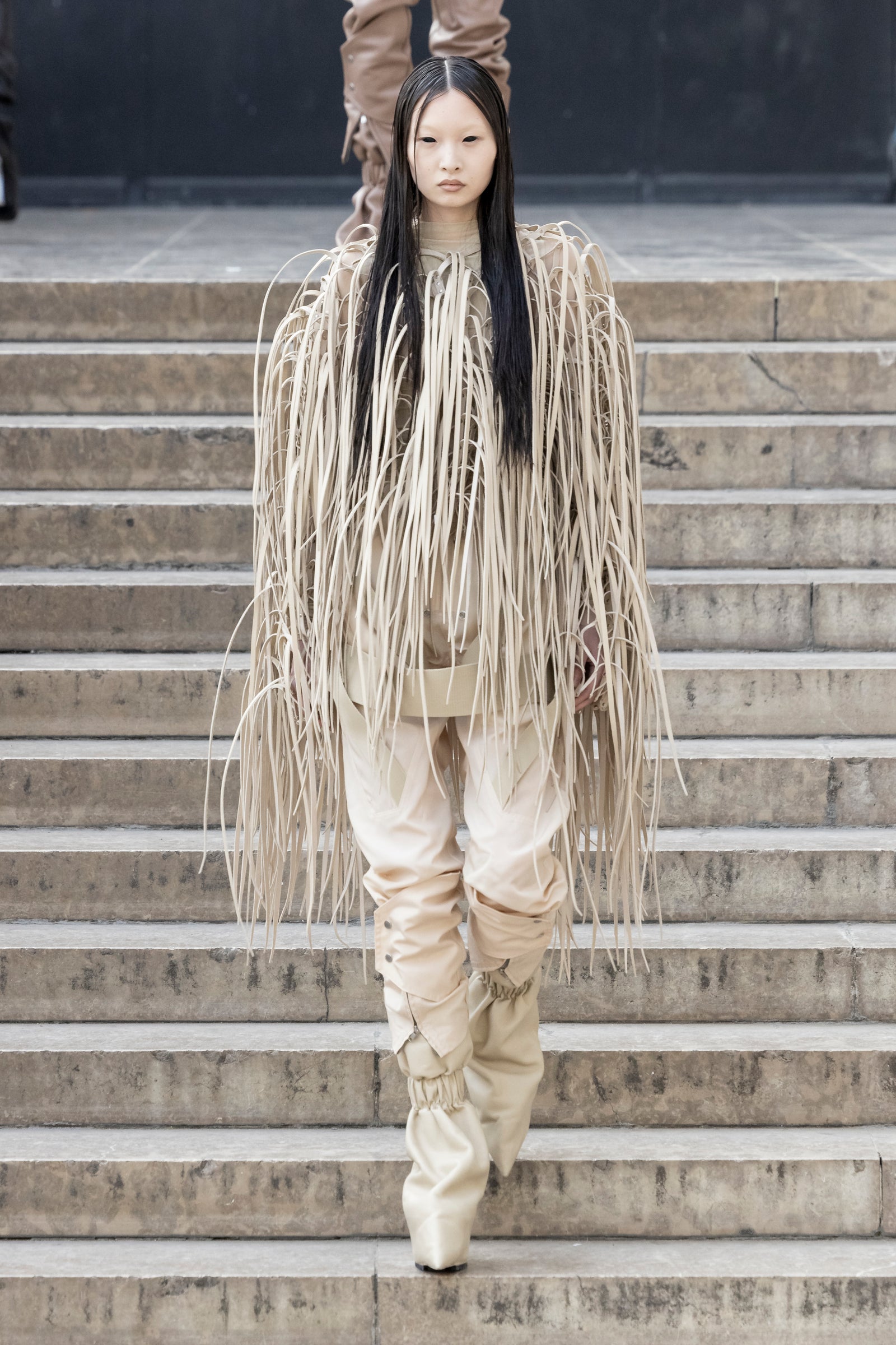 Rick Owens runway look featuring avant garde layered outfit with sculptural silhouette and dark tonal styling