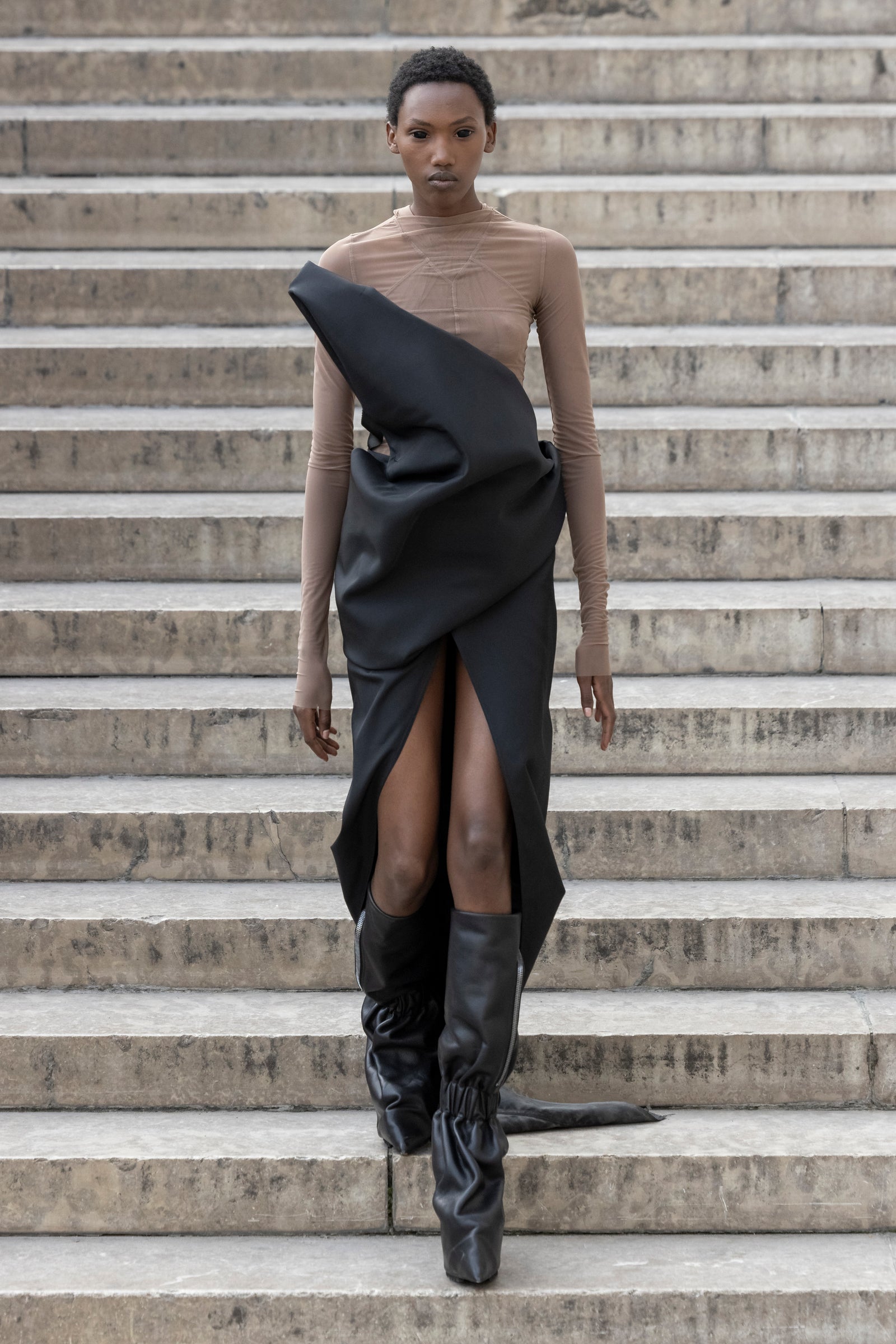 Rick Owens runway look featuring avant garde layered outfit with sculptural silhouette and dark tonal styling