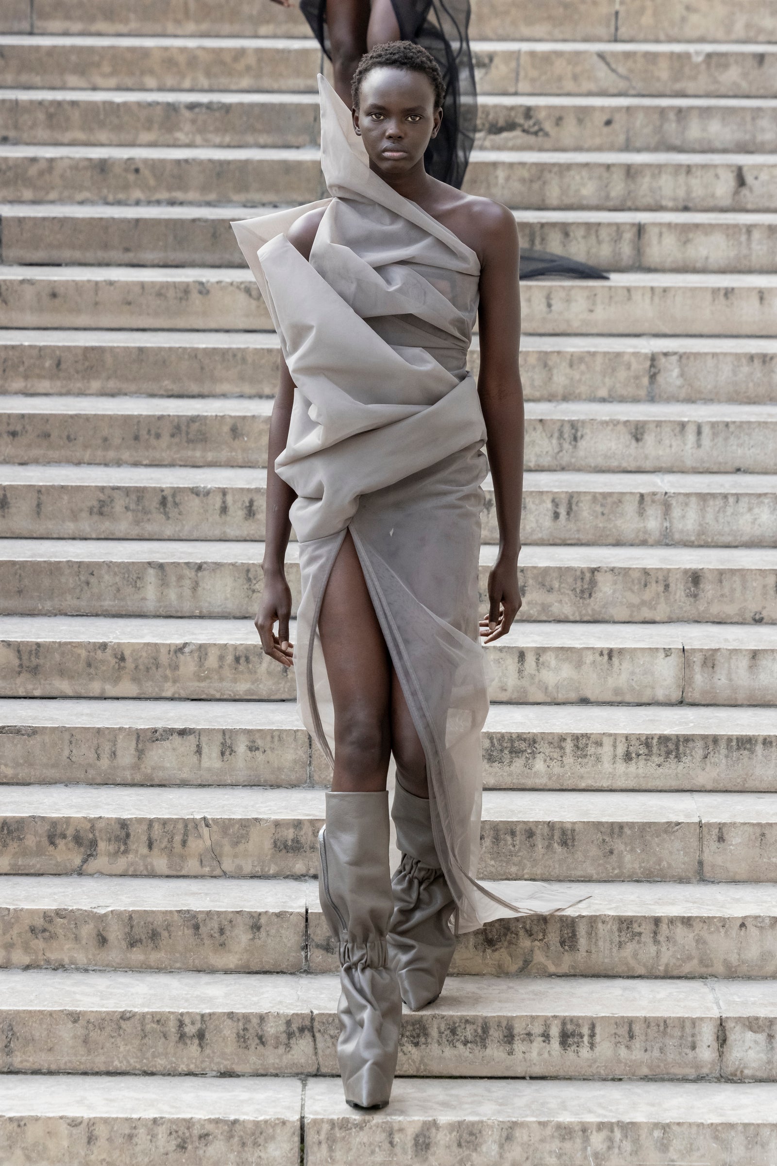 Rick Owens runway look featuring avant garde layered outfit with sculptural silhouette and dark tonal styling