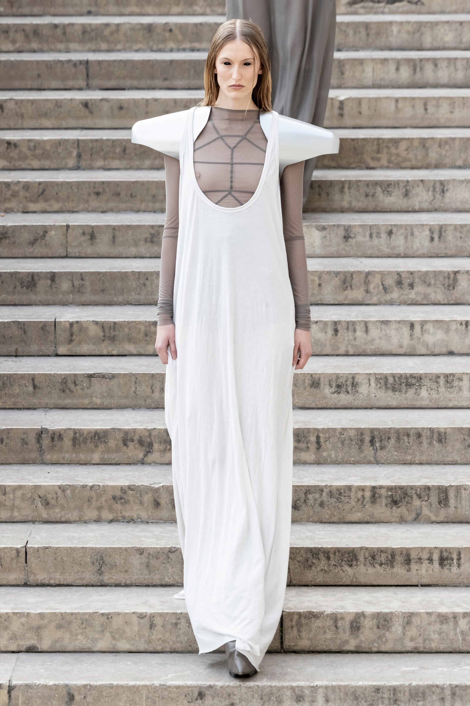 Rick Owens runway look featuring avant garde layered outfit with sculptural silhouette and dark tonal styling