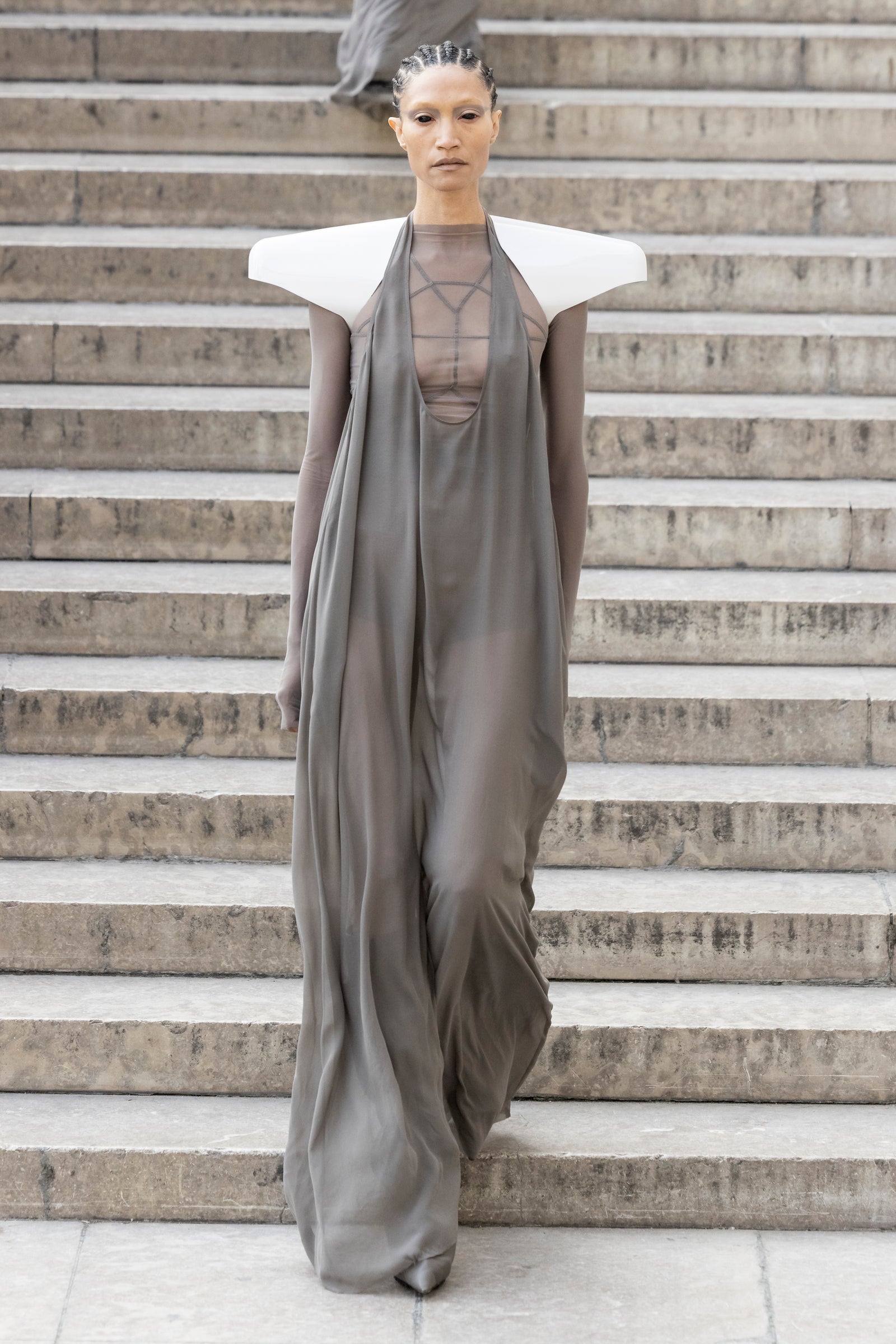 Rick Owens runway look featuring avant garde layered outfit with sculptural silhouette and dark tonal styling