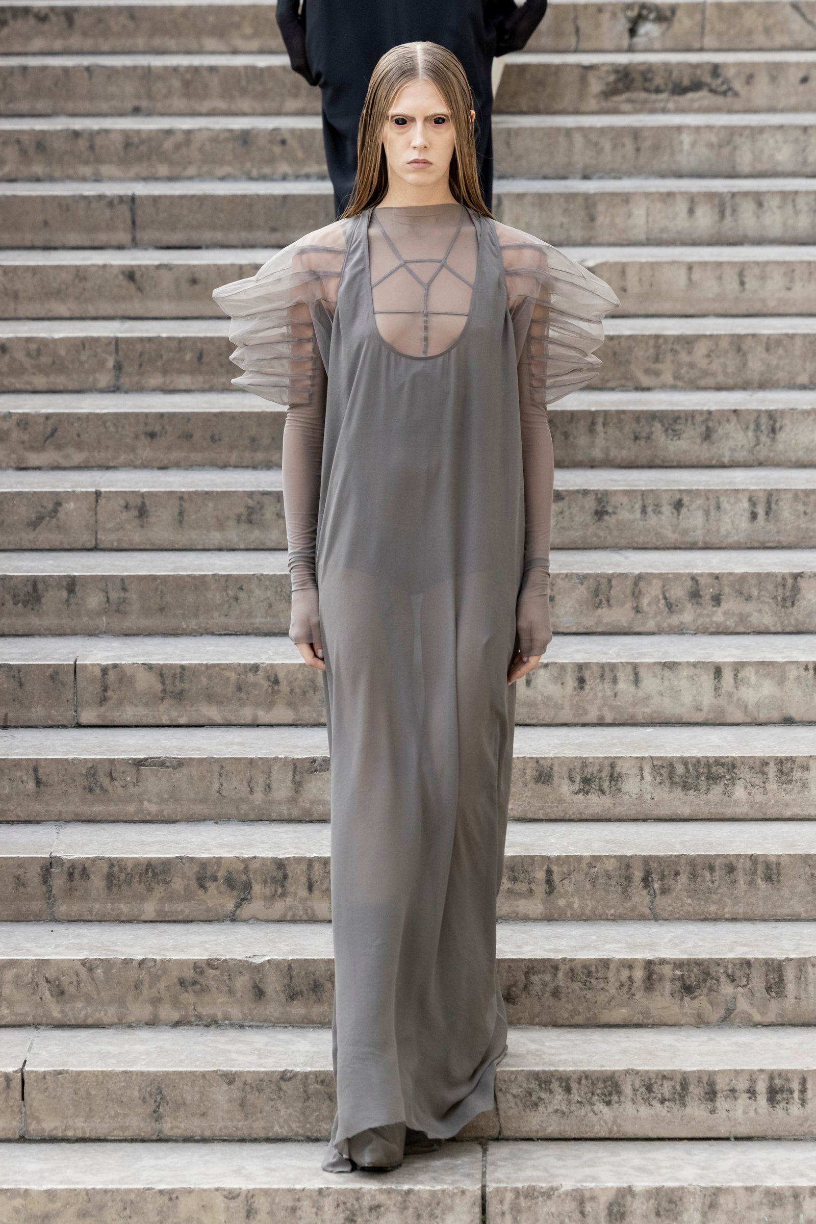Rick Owens runway look featuring avant garde layered outfit with sculptural silhouette and dark tonal styling