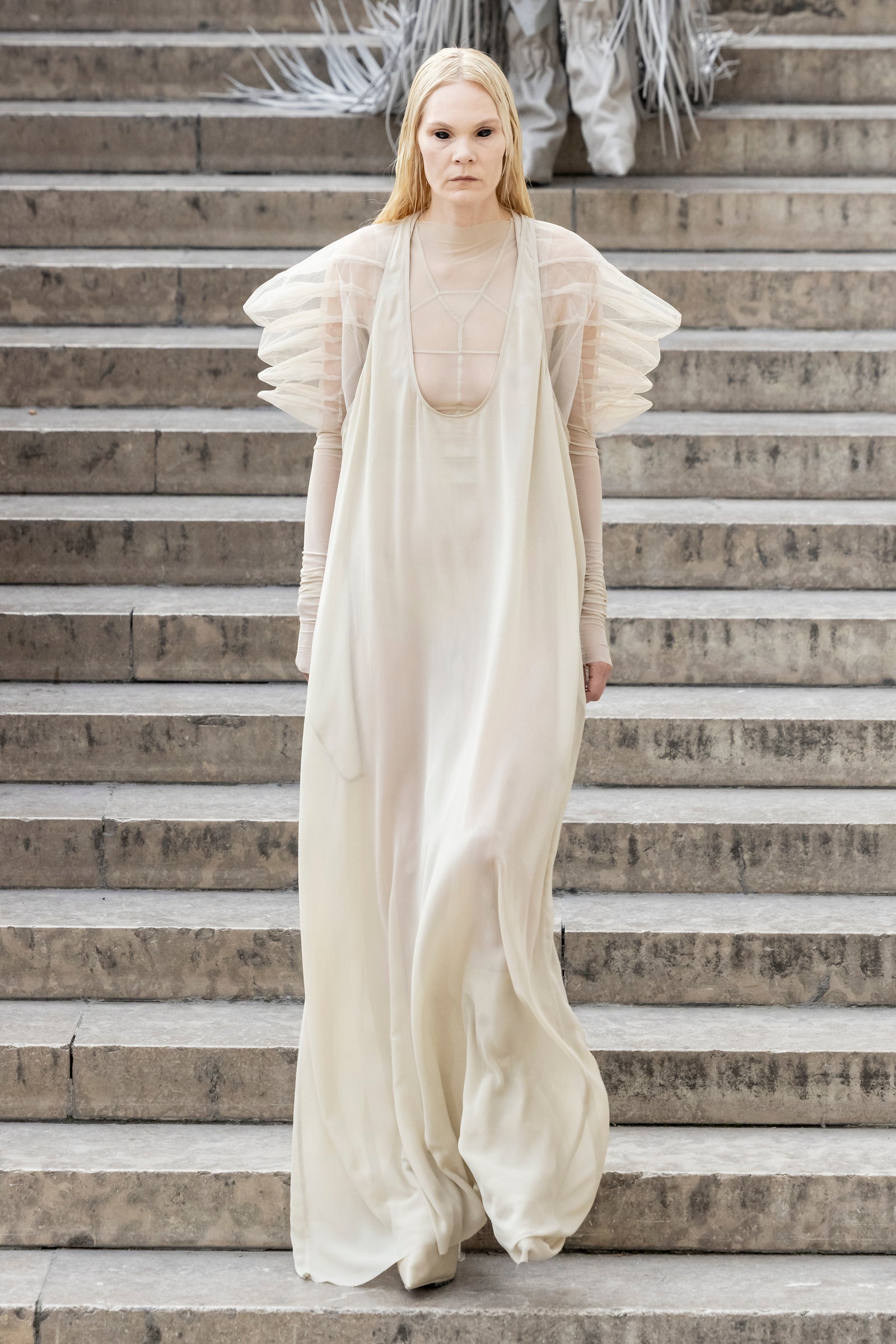 Rick Owens runway look featuring avant garde layered outfit with sculptural silhouette and dark tonal styling