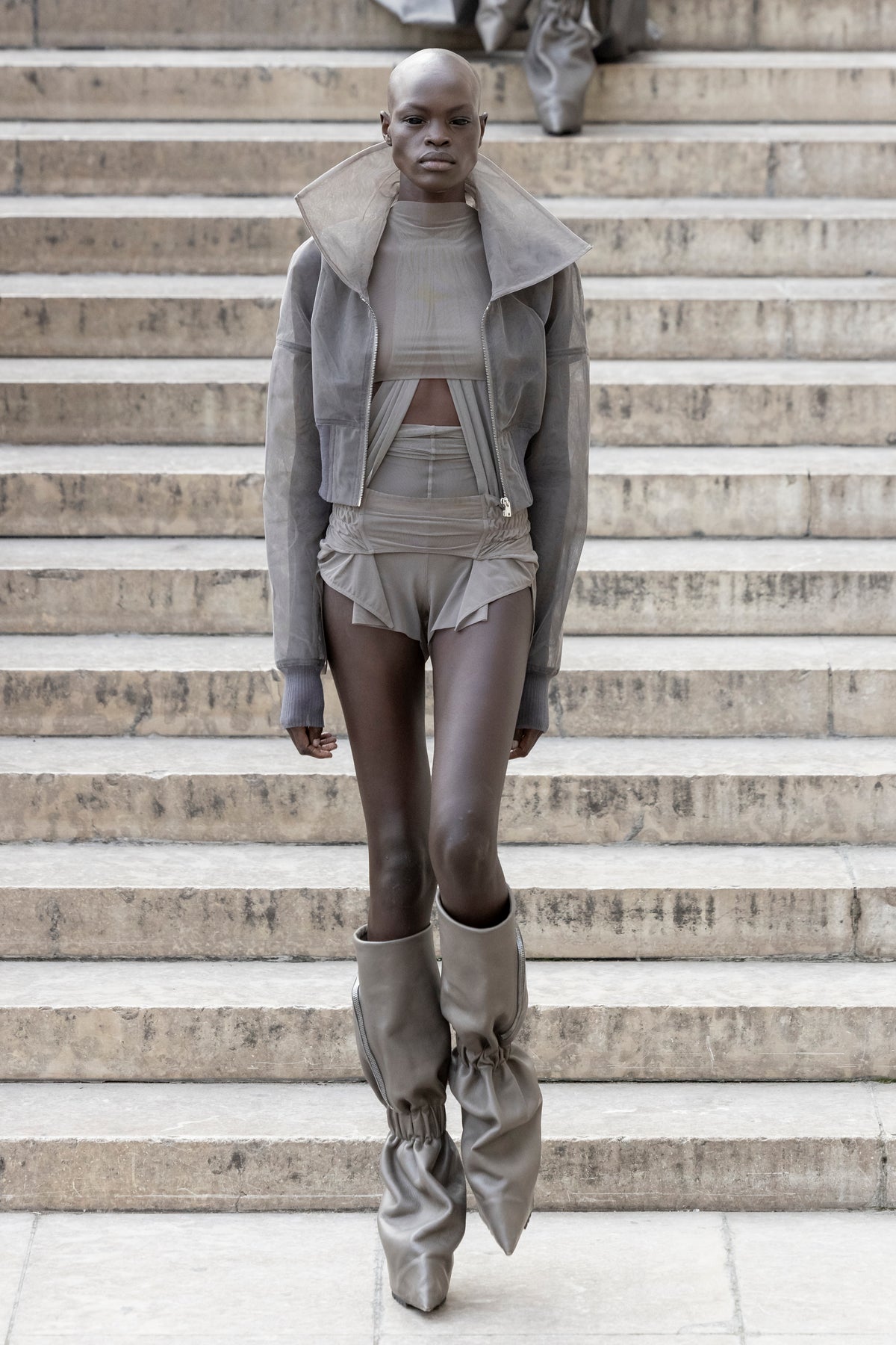 Rick Owens runway look featuring avant garde layered outfit with sculptural silhouette and dark tonal styling