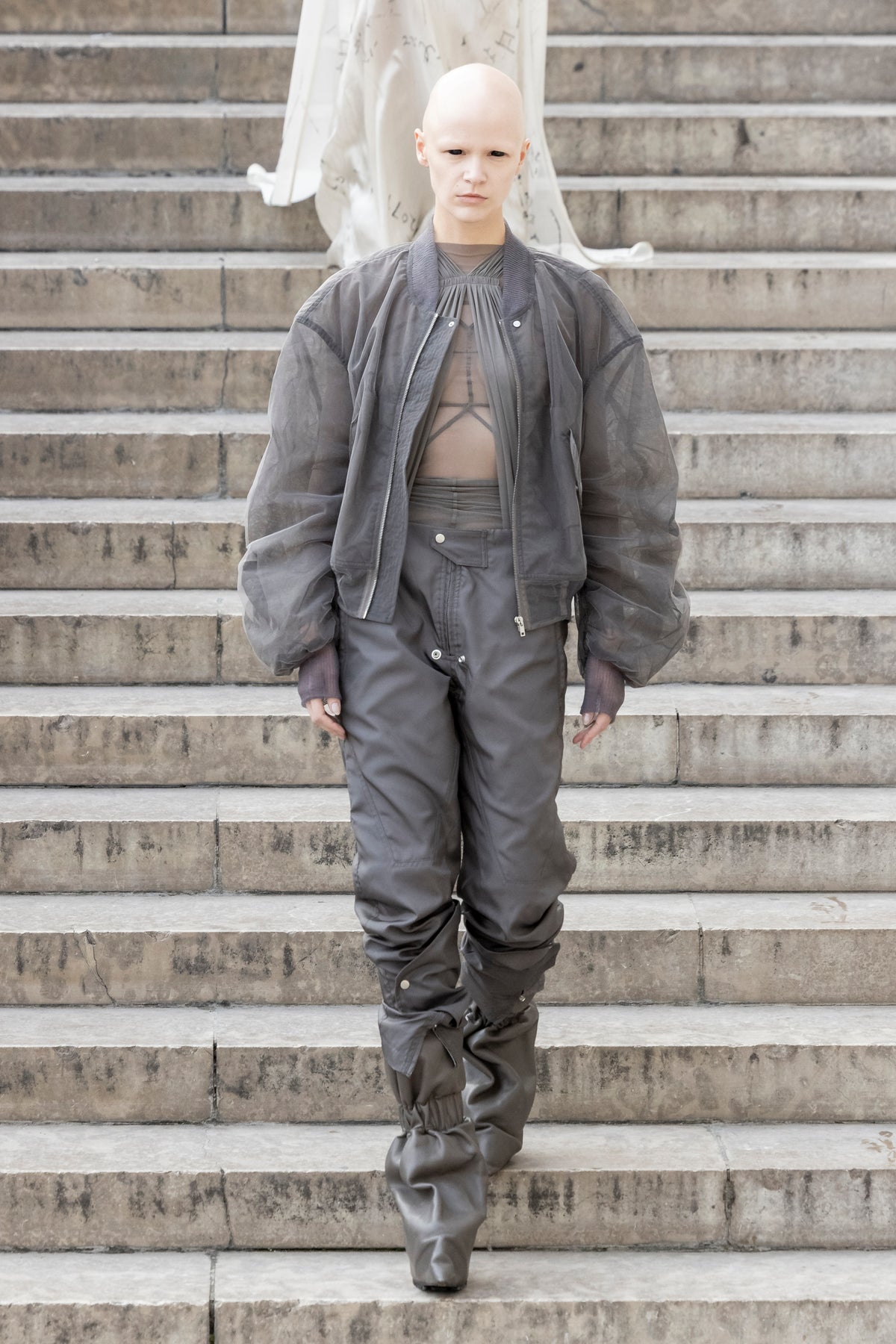 Rick Owens runway look featuring avant garde layered outfit with sculptural silhouette and dark tonal styling